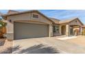 Close-up of the two-car garage and covered entrance, accentuating the home's practical layout at 43554 W Sunland Dr, Maricopa, AZ 85138