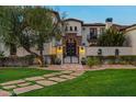 Beautifully landscaped home with a stone walkway leading to an arched entryway and gate at 5016 E Butler Dr, Paradise Valley, AZ 85253