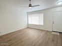 Bright living room with wood-look flooring, a ceiling fan, and natural light from large windows at 60 W Shamrock St, Gilbert, AZ 85233