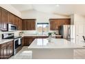 Modern kitchen with stainless steel appliances, quartz countertops, and dark wood cabinets at 7712 N 54Th Ln, Glendale, AZ 85301