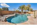 Backyard pool oasis with rock waterfall, palm trees, and privacy wall at 7712 N 54Th Ln, Glendale, AZ 85301