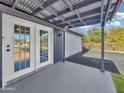 A covered patio features double doors and a view of the two car garage and landscaped backyard at 776 S Saguaro Dr, Apache Junction, AZ 85120