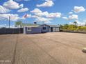 View of the side and back of a charming single-story home featuring an American flag and large gravel yard at 776 S Saguaro Dr, Apache Junction, AZ 85120