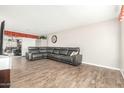 Living room with wood floors, a comfortable leather couch, and a view to the outside at 902 S Saranac Ave, Mesa, AZ 85208