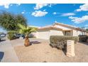 Street view of a well-kept single-story home with desert landscaping and an attached garage at 10814 W Alvarado Rd, Avondale, AZ 85392