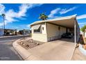 Charming mobile home with a covered carport, set in a peaceful community with ample parking space and desert landscaping at 11411 N 91St Ave # 48, Peoria, AZ 85345