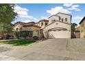 Beautiful two-story home with a spacious driveway, lush green lawn, and mature landscaping for a welcoming curb appeal at 16018 W Shangri La Rd, Surprise, AZ 85379