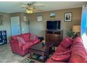 A cozy living room with carpet, 2 red sofas and a ceiling fan at 16657 E Gunsight Dr # 182, Fountain Hills, AZ 85268