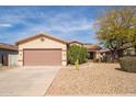 Single-story home featuring desert landscaping, a two-car garage and neutral color palette at 17560 W East Wind Ave, Goodyear, AZ 85338