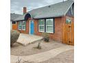 A quaint brick house showcases a blue front door and xeriscaping, blending charm with water conservation at 1953 W Granada Rd, Phoenix, AZ 85009