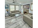 Cozy living area featuring a stone fireplace, neutral furnishings, and ample natural light from large windows at 1953 W Granada Rd, Phoenix, AZ 85009