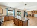 Open kitchen featuring wood cabinetry, central island, and a view of the outdoor living space at 3410 E Pageant Pl, Gilbert, AZ 85297