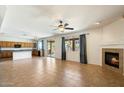 Spacious living room with fireplace, tile floors, natural light and seamless flow to the kitchen at 3410 E Pageant Pl, Gilbert, AZ 85297