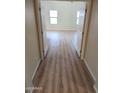 Inviting hallway leading to bedrooms with new wood floors and natural light at 36452 W Velazquez Dr, Maricopa, AZ 85138