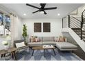 Inviting living room with a comfortable sectional sofa, stylish decor, ceiling fan, and modern staircase at 6845 E Osborn Rd # D, Scottsdale, AZ 85251