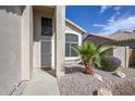 Exterior view of the front entrance with desert landscaping, rocks and a palm tree at 7420 W Los Gatos Dr, Glendale, AZ 85310
