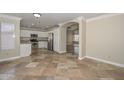 Kitchen with stainless steel appliances, white cabinets, tile floors and granite countertops at 7420 W Los Gatos Dr, Glendale, AZ 85310