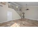 Bright living room with tile floors, high ceilings, a fan, and a staircase at 7420 W Los Gatos Dr, Glendale, AZ 85310