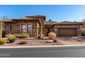 Beautiful stone home featuring a tile roof, two car garage, and desert landscaping at 8041 E Teton Cir, Mesa, AZ 85207
