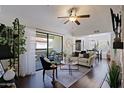 Cozy living room featuring hardwood floors, a ceiling fan, and a sliding glass door to the outdoor patio at 9990 N Scottsdale Rd # 2020, Paradise Valley, AZ 85253