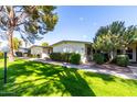 Manicured lawns and mature trees accent this community with a warm inviting exterior at 10511 W Wheatridge Dr, Sun City, AZ 85373