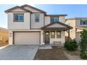 Charming two-story home features a beige exterior, covered entry, two-car garage, and manicured landscaping at 10983 W Mckinley St, Avondale, AZ 85323