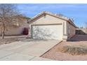 View of a desert landscape with a two-car garage and desert front yard at 12246 W Bloomfield Rd, El Mirage, AZ 85335