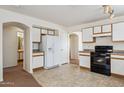 Open concept kitchen with white cabinets and black appliances at 12246 W Bloomfield Rd, El Mirage, AZ 85335