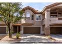 Three-story townhouse with brown trim, arched windows, attached garages, and mature landscaping at 14000 N 94Th St # 1118, Scottsdale, AZ 85260