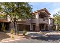 Three-story townhouse with brown trim, arched windows, attached garages, and mature landscaping at 14000 N 94Th St # 1118, Scottsdale, AZ 85260