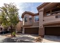 Three-story townhouse with brown trim, arched windows, attached garages, and mature landscaping at 14000 N 94Th St # 1118, Scottsdale, AZ 85260