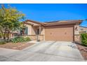 Charming single-story home featuring a desert landscape, a two-car garage, and a stone-accented facade at 14296 W Surrey Dr, Surprise, AZ 85379