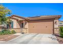 Charming single-story home featuring a desert landscape, a two-car garage, and a stone-accented facade at 14296 W Surrey Dr, Surprise, AZ 85379