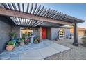 Inviting front entrance featuring decorative plants, a water feature, and a cozy pergola at 15034 N 54Th St, Scottsdale, AZ 85254