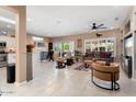 Bright and airy living room featuring tile floors, a ceiling fan, and large sliding glass doors to the patio at 16200 W Hearthstone Dr, Surprise, AZ 85374