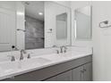 Beautiful bathroom with a double sink vanity, large mirror and stylish tiled shower at 1811 N Brower Ln, Maricopa, AZ 85139