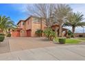 Beautiful two-story home with three-car garage, desert landscaping, and a brick driveway at 20396 E Via Del Rancho Rd, Queen Creek, AZ 85142