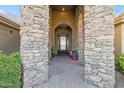 Arched stone entry showcasing a decorative iron door with chandelier above at 23415 S 202Nd St, Queen Creek, AZ 85142