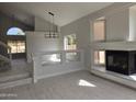 Bright and airy living room featuring a fireplace, staircase, and vaulted ceiling at 31487 N Blackfoot Dr, San Tan Valley, AZ 85143