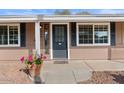 Inviting front entrance featuring a gray door with sidelights and decorative potted plants at 3724 E Joan De Arc Ave, Phoenix, AZ 85032