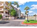 Condo exterior featuring manicured landscaping, palm trees, and a well-maintained building facade at 4200 N Miller Rd # 220, Scottsdale, AZ 85251