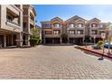 Three-story condo exterior features neutral colors, garages, and brick driveways at 4455 E Paradise Village S Pkwy # 1068, Phoenix, AZ 85032