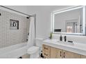 Modern bathroom featuring a patterned-tile shower, white toilet, and lit mirror at 8245 E Bell Rd # 201, Scottsdale, AZ 85260