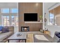 Cozy living room featuring a fireplace, wooden accent wall, and comfortable seating at 8245 E Bell Rd # 201, Scottsdale, AZ 85260