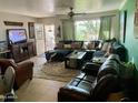 Cozy living room featuring a large sectional sofa, area rug, and a sunny window with views of the front yard at 8732 E Arlington Rd, Scottsdale, AZ 85250