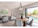 An indoor/outdoor dining space with views to the pool and an open layout to living room at 9812 E Karen Dr, Scottsdale, AZ 85260