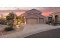 Exterior of the home, showing the desert landscaping and two car garage at 9812 E Karen Dr, Scottsdale, AZ 85260