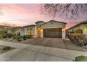 Charming single-story home features desert landscaping, a two-car garage and a barrel-tile roof at dusk at 10719 E Simone Ave, Mesa, AZ 85212