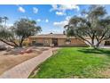 Charming brick home with a well-manicured lawn and mature trees. Features a brick walkway and a cozy, inviting facade at 11420 N 50Th St, Scottsdale, AZ 85254