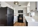Well-lit kitchen featuring black appliances, white cabinetry, and light countertops at 1320 E Bethany Home Rd # 24, Phoenix, AZ 85014